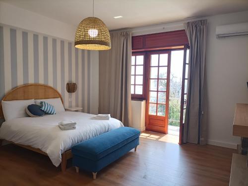a bedroom with a bed and a blue ottoman at Casa Teranga in Furore