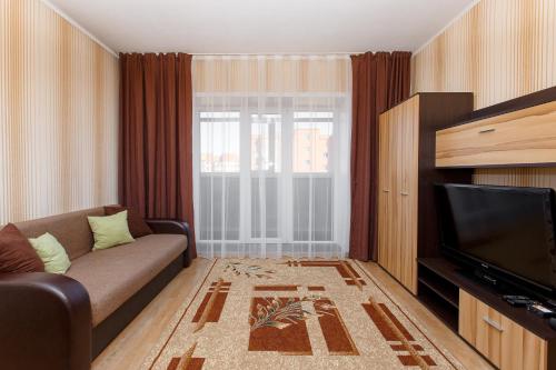 sala de estar con sofá y TV en 1-комн. кв. в ЖК Дуэт, en Kokshetau