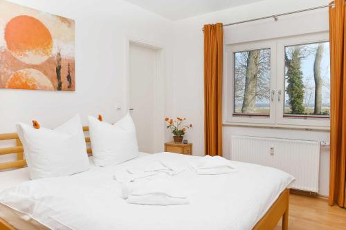 a white bed in a room with a window at Gutshaus von Bülow - 19-02 in Kägsdorf