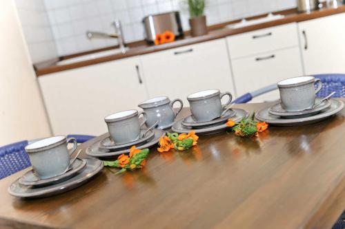 Una mesa con cuatro tazas de café y flores. en Gutshaus von Bülow - 19-05, en Kägsdorf