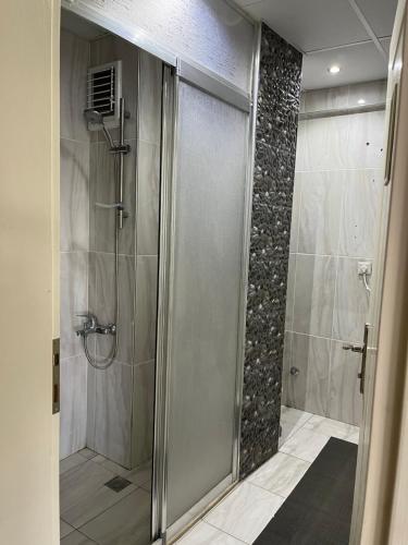 um chuveiro com uma porta de vidro na casa de banho em Grand Teoshan Otel ve Tatil Evleri em Seferihisar