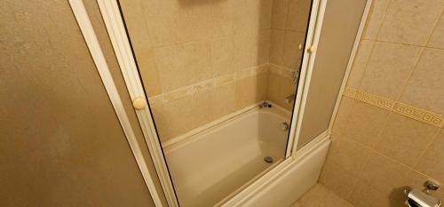 a bathroom with a shower with a tub at Altın Koza Hotel in Adana