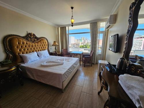 a bedroom with a large bed with a large window at Altın Koza Hotel in Adana