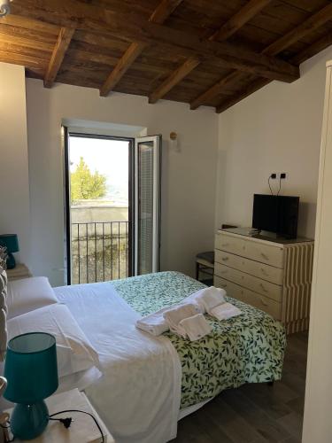 a bedroom with a bed and a television and a window at Quartuccio a Pereto in Pereto