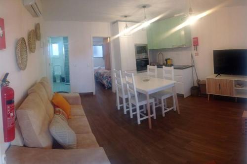 ein Wohnzimmer und eine Küche mit einem Sofa und einem Tisch in der Unterkunft Sado House 3 in Comporta