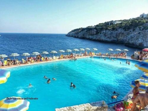 a large pool with people in the water with umbrellas at Villaelena in Marittima