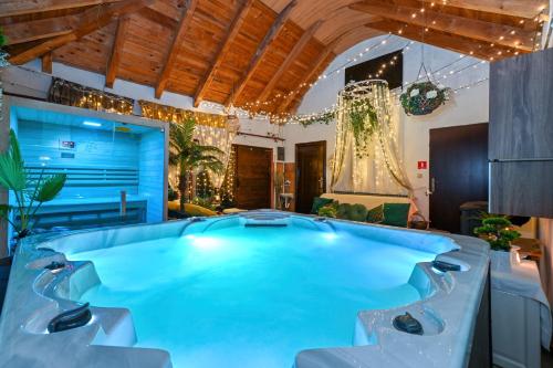 a large swimming pool in a living room with a wooden ceiling at Privatni apartman u vili ,privatni bazen, privatni wellness - jacuzzi, finska sauna in Črnec Biškupečki