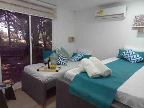Cette chambre comprend 2 lits avec des oreillers bleus et blancs. dans l'établissement Linda cabaña en Isla frente a Cartagena, à Carthagène des Indes