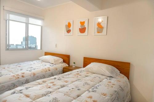 1 dormitorio con 2 camas y ventana en Lovely Aparment OceanView Barranco1809, en Lima