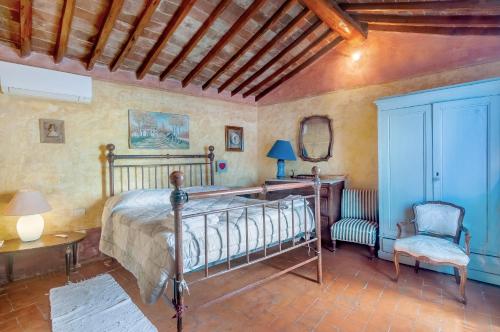 um quarto com uma cama, uma cadeira e uma mesa em Poggio alla Pieve - Blu em Calenzano
