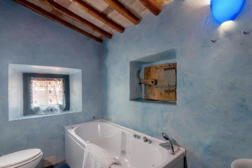 uma casa de banho com uma banheira branca e um WC. em Poggio alla Pieve - Blu em Calenzano