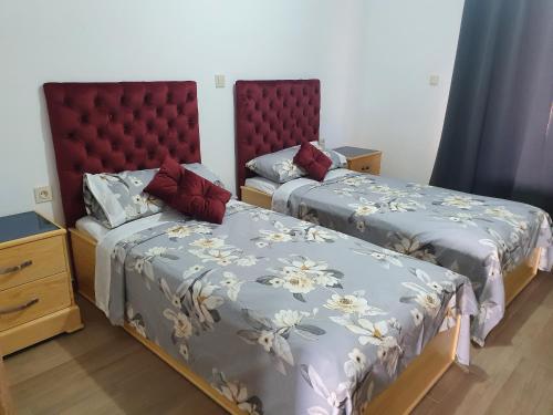 a bedroom with two beds and a headboard at Appart calme, neuf à 5mn de la plage SAADIA in Saidia 