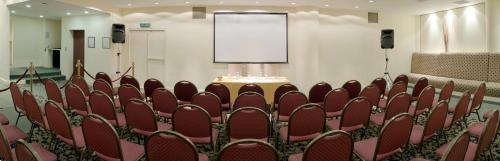 a row of chairs in a room with a screen at Hotel Dos Reyes in Mar del Plata