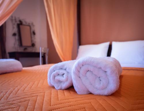 two rolls of towels sitting on top of a bed at Elena Studios and apartments in Nea Iraklia