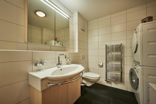 uma casa de banho com um lavatório, um WC e um espelho. em Apartment Mountain View, Luxury, Spacious with best Views em Lauterbrunnen