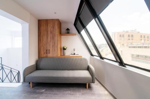 einen Stuhl in einem Zimmer mit großen Fenstern in der Unterkunft Olvia Suites in Athen