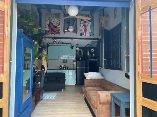 a living room with a couch and a kitchen at Casa Rural Alfoz, -Tiny house- con patio privado, barbacoa, wifi, netflix, Aire acondicionado in Velliza