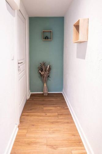 a hallway with a vase with a plant in it at appart de charme a 2 pas du centre de Montbrison in Montbrison