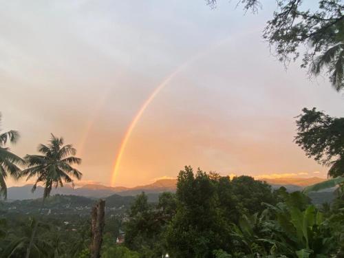 a rainbow in the sky over a city at Pearl's Homestay Matale in Matale