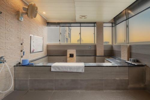 uma casa de banho com um balcão com um lavatório em 沐-湯宿溫泉行旅 em Jiaoxi