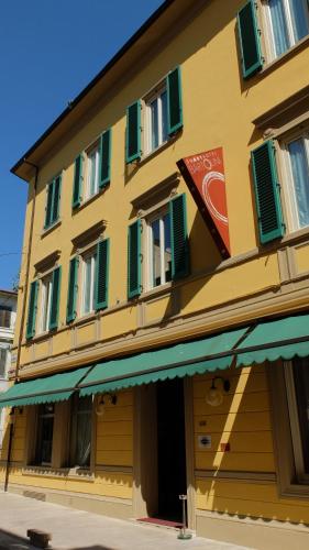 a yellow building with green shutters on it at SmArt Hotel Bartolini in Montecatini Terme