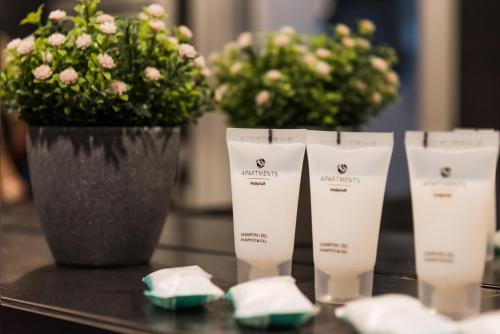 a table with a vase of flowers and a group of products at Central Apartments by Bed&Bath in Kraków