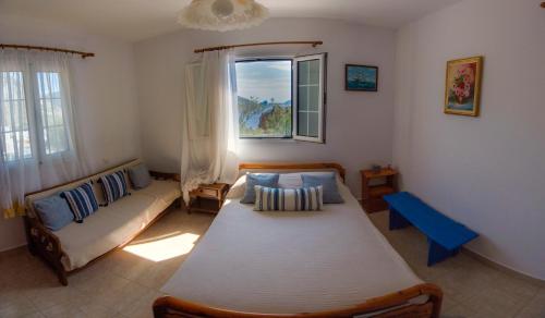 a bedroom with a bed and a couch and a window at Maria Nik Psaras House in Kalymnos