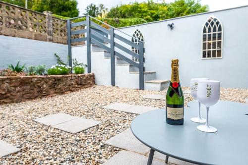 a bottle of wine sitting on a table with a glass at Gingerbread Lodge in Torquay