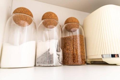four glass containers of food sitting on a shelf next to a microwave at Gingerbread Lodge in Torquay