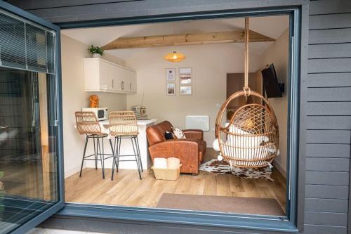 a living room with a couch and a swing at Gingerbread Lodge in Torquay