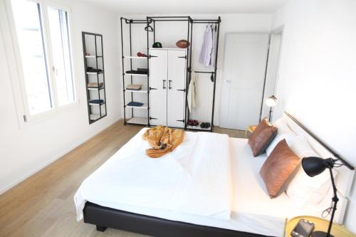 sypialnia z łóżkiem z białą pościelą i drewnianą podłogą w obiekcie Nest - Kanzleistrasse 217 w Zurychu