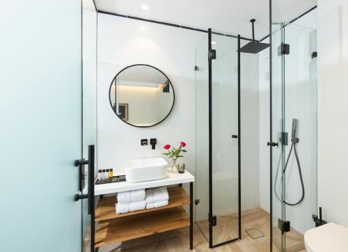 bagno con doccia in vetro e lavandino di Rephael House Boutique Hotel a Rishon LeẔiyyon