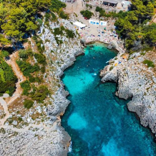 an aerial view of a cove with blue water at Villaelena in Marittima