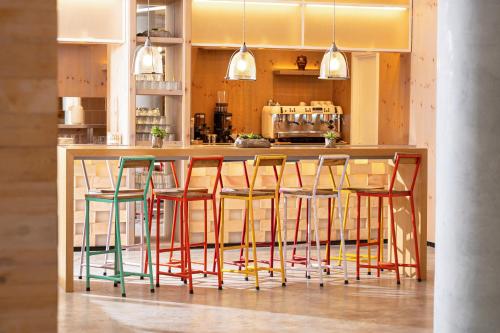 a kitchen with a bar with colorful stools at INNSiDE by Meliá Calviá Beach in Magaluf