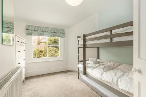 a bedroom with a bunk bed and a window at Beautiful Edwardian Central Oxford home in Oxford