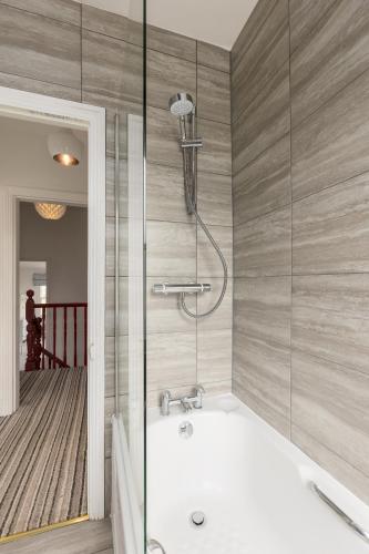 a bathroom with a shower and a bath tub at Beautiful Edwardian Central Oxford home in Oxford