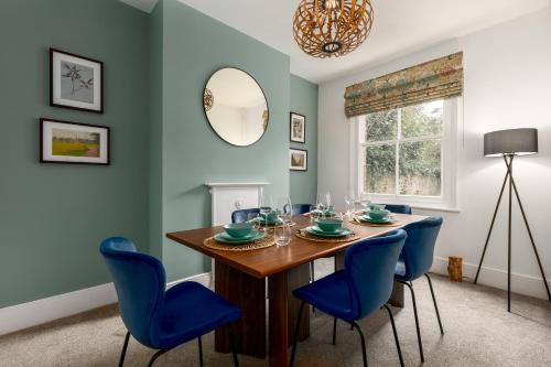 a dining room with a table and blue chairs at Beautiful Edwardian Central Oxford home in Oxford