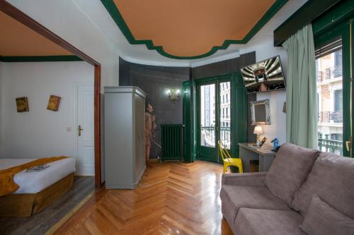 salon z zielonymi ścianami i kanapą w obiekcie Casual del Teatro Madrid w Madrycie