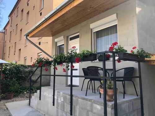 Un patio con mesa y sillas y flores. en Móra apartman 3., en Kiskunfélegyháza