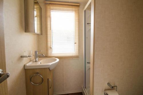 y baño con lavabo y ducha. en Brilliant 8 Berth Caravan At Haven Caister Holiday Park In Norfolk Ref 30024d, en Great Yarmouth