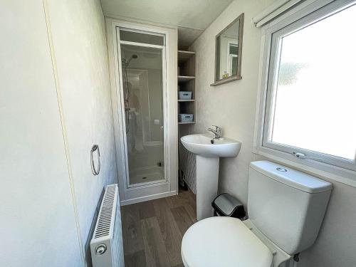 a bathroom with a toilet and a sink at Gorgeous Caravan With Decking In Breydon Water Holiday Park, Ref 10081b in Belton