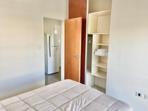 a room with a bed and a refrigerator at Departamento moderno y equipado 3-B in Corrientes