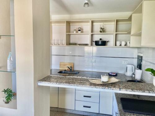 a kitchen with white cabinets and a counter top at Departamento moderno y equipado 3-B in Corrientes