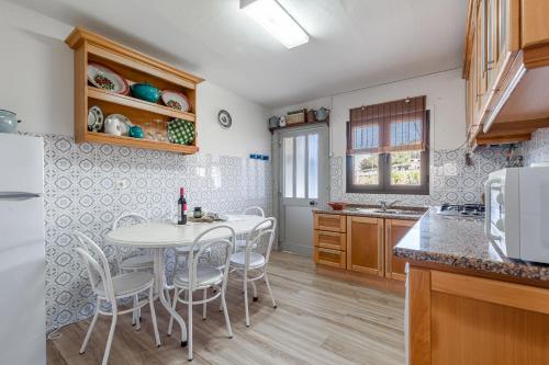 a kitchen with a table and chairs in a kitchen at Casa da Varzinha in A dos Cunhados