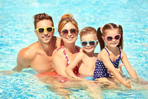 a family in the water at a swimming pool at 8 Berth Caravan With Decking And Wifi At Broadland Sands Park Ref 20064Cf in Hopton on Sea