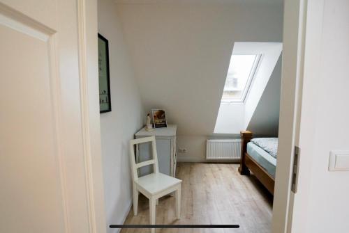 a room with a chair and a bed and a window at Traumhafte Ferienwohnung im Landhausstil in Hanshagen