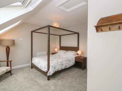 um quarto com uma cama de dossel num sótão em 1 Crud Y Mor em Barmouth