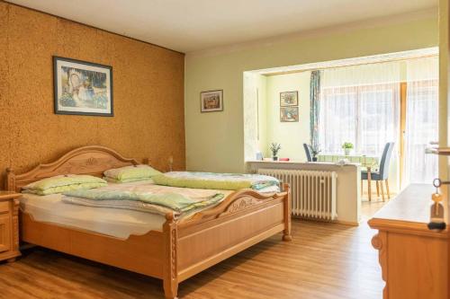 a bedroom with a bed and a table and a window at Landgasthof Peterhof in Etzelwang