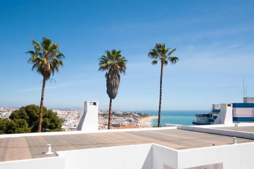 a view from the roof of a building with palm trees at Windmill by OCvillas in Albufeira