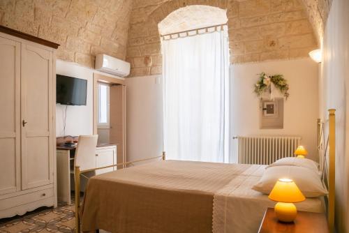 a bedroom with a bed with a table and a window at PESCIOLINO B&B in Mola di Bari